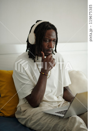 Thinking Person Sitting with Laptop in Modern Setting 119675385