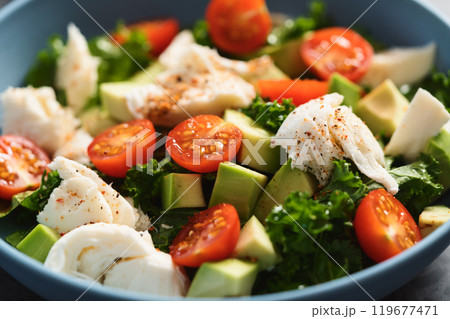 Salad with avocado, mozzarella, tomatoes and kale in blue ceramic bowl Salad with avocado, mozzarella, tomatoes and kale in blue ceramic bowl 119677471