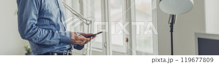 Businessman using digital tablet by office windows Businessman using digital tablet by office windows 119677809