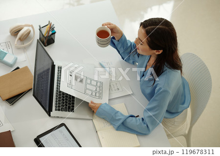 Businesswoman Reviewing Digital Documents with Coffee Businesswoman Reviewing Digital Documents with Coffee 119678311