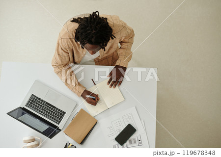 Working on Office Desk With Laptop and Notepad 119678348