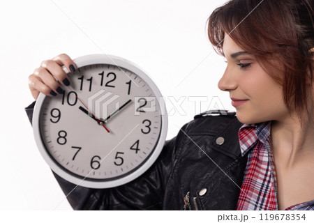 A woman confidently holding a stylish clock while dressed in an elegant and modern attire A woman confidently holding a stylish clock while dressed in an elegant and modern attire 119678354