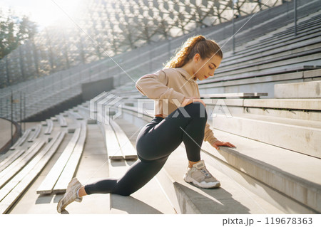 Fitness woman in fashionable sportswear is doing sports outdoors. The concept of active lifestyle. 119678363