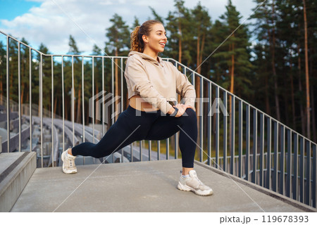 Fitness woman in fashionable sportswear is doing sports outdoors. The concept of active lifestyle. Fitness woman in fashionable sportswear is doing sports outdoors. The concept of active lifestyle. 119678393