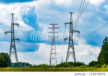 A view of electric power transmission lines stretching across a cloudy sky and scenic landscape in the countryside 119678638