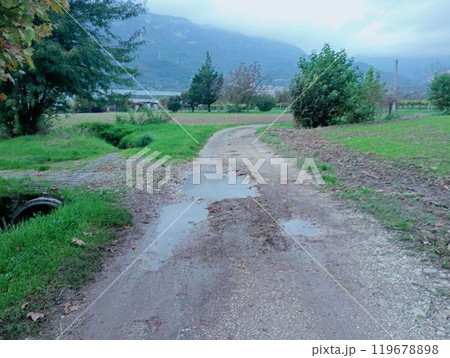 rural road with puddles in northern Italy 119678898