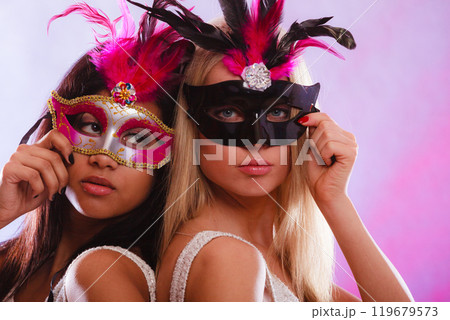 Two women with carnival venetian masks Two women with carnival venetian masks 119679573