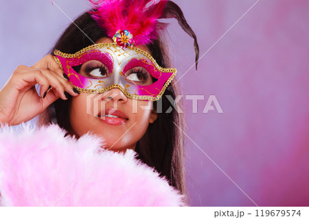 woman with carnival mask holds fan 119679574