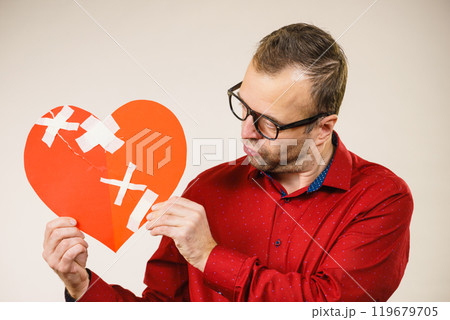 Adult man holding broken heart 119679705