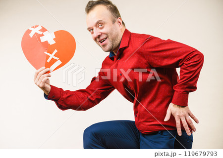 Adult man holding broken heart running Adult man holding broken heart running 119679793