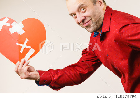 Adult man holding broken heart running Adult man holding broken heart running 119679794