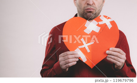 Sad adult man holding broken heart Sad adult man holding broken heart 119679796