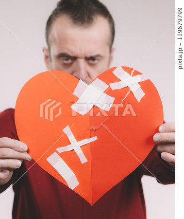 Funny man holds broken heart Funny man holds broken heart 119679799