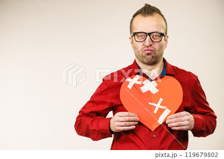 Adult man holding broken heart 119679802