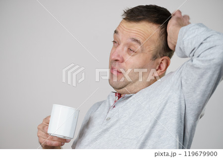 Tired man enjoying his coffee Tired man enjoying his coffee 119679900