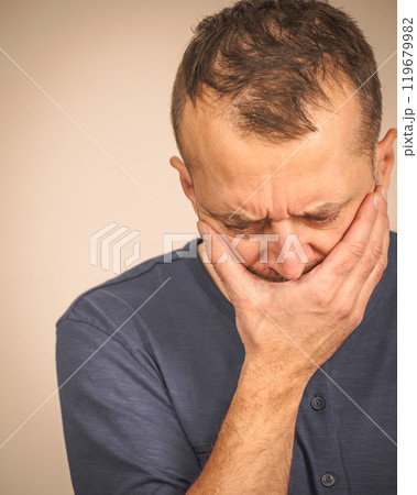 Sad worried man covering his mouth 119679982