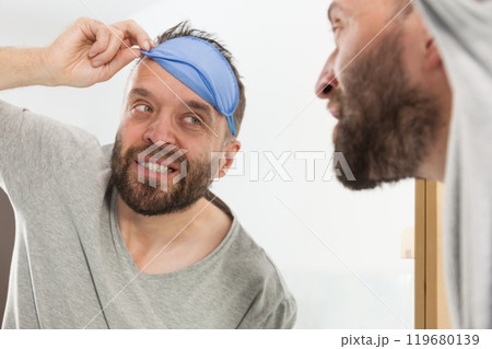 Happy man after sleep looking at mirror Happy man after sleep looking at mirror 119680139
