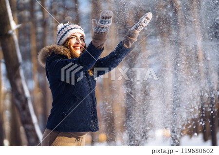 Happy woman plays with snow in sunny winter day. Girl enjoys winter, frosty day. Playing with snow. Happy woman plays with snow in sunny winter day. Girl enjoys winter, frosty day. Playing with snow. 119680602