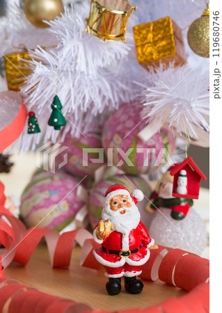 A small figurine of Santa Claus in a red and white suit holding a green sack, A small figurine of Santa Claus in a red and white suit holding a green sack, 119680746