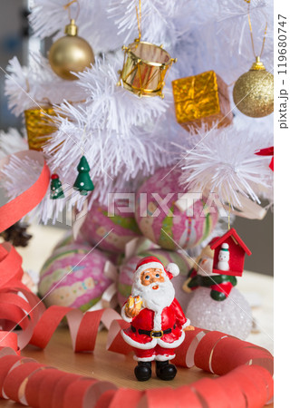 A small figurine of Santa Claus in a red and white suit holding a green sack, A small figurine of Santa Claus in a red and white suit holding a green sack, 119680747