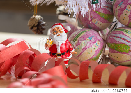 A small figurine of Santa Claus in a red and white suit holding a green sack, A small figurine of Santa Claus in a red and white suit holding a green sack, 119680751