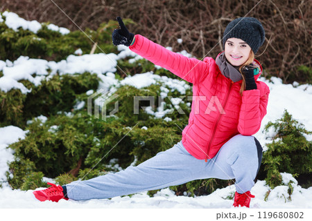 Woman wearing sportswear exercising outside during winter Woman wearing sportswear exercising outside during winter 119680802