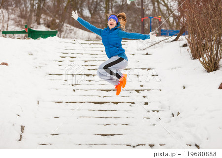 Woman wearing sportswear exercising outside during winter 119680888
