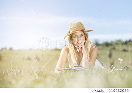 Young beautiful lady enjoying in nature park reading the book Young beautiful lady enjoying in nature park reading the book 119682086