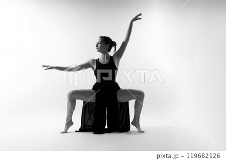 Young and incredibly beautiful ballerina is posing and dancing in a studio full of light. Young and incredibly beautiful ballerina is posing and dancing in a studio full of light. 119682126