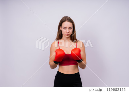 Young tired woman in sportswear and boxing gloves standing isolated on white yellow background. 119682133