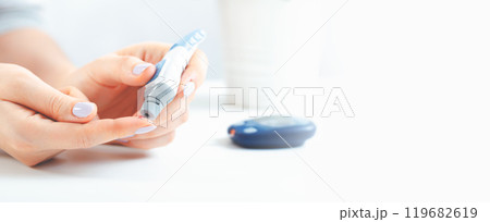 Woman is holding a glucometer 119682619