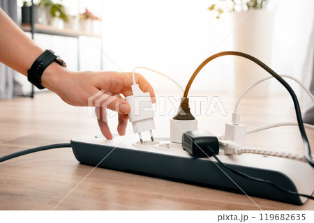 Person is plugging in a device to a power strip Person is plugging in a device to a power strip 119682635