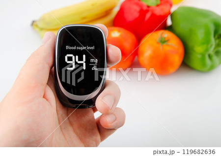 Person is holding a blood sugar monitor Person is holding a blood sugar monitor 119682636