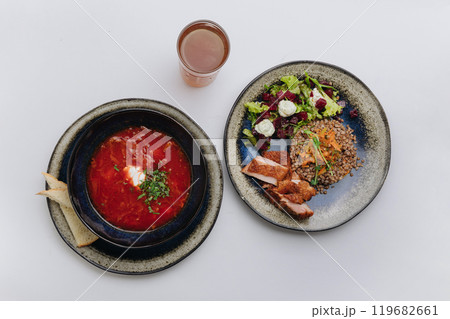 Traditional Ukrainian borscht paired with buckwheat, chicken, and beet salad for a hearty meal 119682661