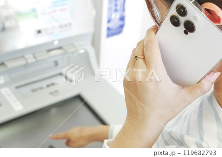 通話しながら銀行ATMを操作する女性 119682793