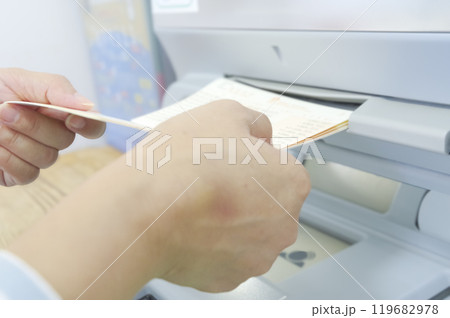 ATMでお金を引き出す女性（顔なし） 119682978