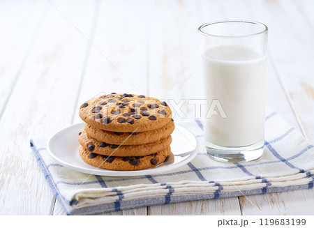 Chocolate chip cookies and milk on a white table, close up. Chocolate chip cookies and milk on a white table, close up. 119683199
