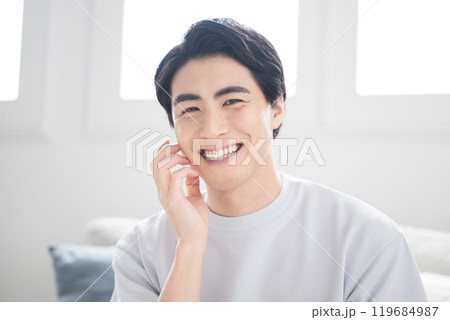 スキンケアをする頬に手をあてる若い男性のビューティーイメージ 119684987