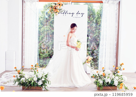 Small wedding - the priest is present, the bride and groom hold their wedding bouquets, hold hands, and share a beautiful moment with family and friends. Small wedding - the priest is present, the bride and groom hold their wedding bouquets, hold hands, and share a beautiful moment with family and friends. 119685959