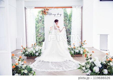 Small wedding - the priest is present, the bride and groom hold their wedding bouquets, hold hands, and share a beautiful moment with family and friends. Small wedding - the priest is present, the bride and groom hold their wedding bouquets, hold hands, and share a beautiful moment with family and friends. 119686026