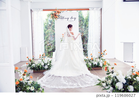 Small wedding - the priest is present, the bride and groom hold their wedding bouquets, hold hands, and share a beautiful moment with family and friends. 119686027