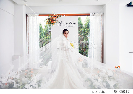 Small wedding - the priest is present, the bride and groom hold their wedding bouquets, hold hands, and share a beautiful moment with family and friends. 119686037