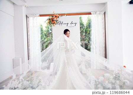 Small wedding - the priest is present, the bride and groom hold their wedding bouquets, hold hands, and share a beautiful moment with family and friends. Small wedding - the priest is present, the bride and groom hold their wedding bouquets, hold hands, and share a beautiful moment with family and friends. 119686044