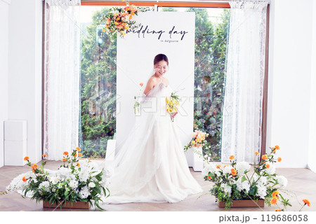 Small wedding - the priest is present, the bride and groom hold their wedding bouquets, hold hands, and share a beautiful moment with family and friends. 119686058