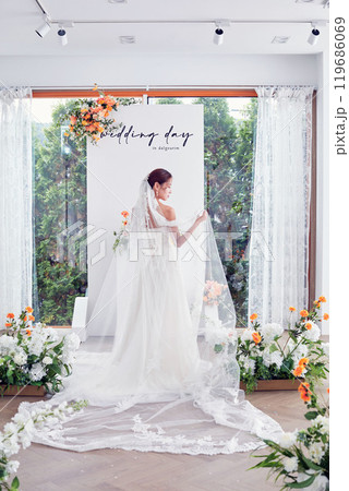 Small wedding - the priest is present, the bride and groom hold their wedding bouquets, hold hands, and share a beautiful moment with family and friends. 119686069