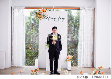 Small wedding - the priest is present, the bride and groom hold their wedding bouquets, hold hands, and share a beautiful moment with family and friends. Small wedding - the priest is present, the bride and groom hold their wedding bouquets, hold hands, and share a beautiful moment with family and friends. 119686153