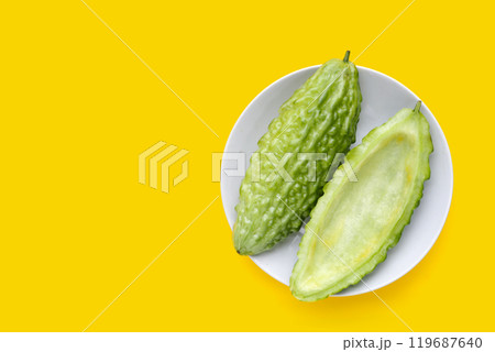 Bitter melon in in white plate on yellow background. 119687640