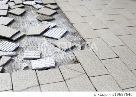 Cracked brown tiles on cement floor 119687646