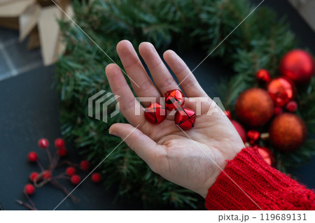 Handmade Christmas wreath from festive red decorations. Festive holiday preparation craft master class of creative making decor. Hands-on activities sustainable responsible holiday gift workshop 119689131