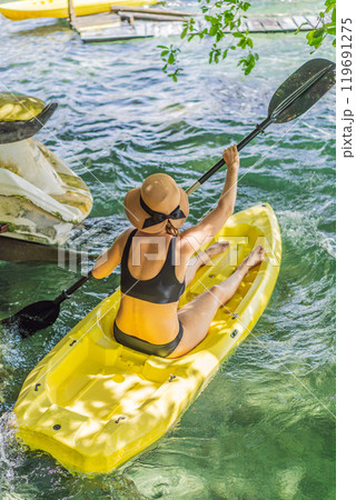 Woman kayaking on Bacalar Lake in Mexico. Adventure tourism in Quintana Roo, outdoor exploration, and water activities concept 119691275